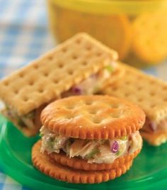 two crackers are stacked on top of each other with chicken salad in between them