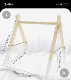 a wooden swing frame with measurements for the top and bottom bars on it, sitting in front of a white background