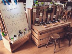 an easel and some wooden crates with plants on them