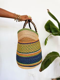 A beautiful authentic one-of-a-kind handwoven market basket tote handmade in Bogatanga. Each bag is beautifully woven by hand with thick, natural and dyed elephants grass to create a beautiful pattern and leather wrapped handles. This is the perfect market bag for trips to the farmers market, the beach, picnics or storage. Size: 13”H x 17”W x 10”D *One-of-a-kind, 1 of 1. Top Handle Natural Bucket Bag For Market, Natural Top Handle Bucket Bag For Market, Weaving Straw Bucket Bag For Market, Bucket Straw Bag With Weaving For Market, Market Bucket Straw Bag With Weaving, Natural Fiber Crochet Bag With Leather Handles For Market, Top Handle Woven Beach Bag For Market, Fair Trade Basket Crochet Bag For Travel, Fair Trade Crochet Basket Bag For Travel