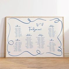 a white and blue wedding seating chart in front of a wooden frame on the floor