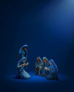 three nativity figurines sitting on the floor in front of a blue background