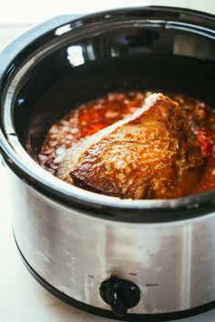 a crock pot filled with food sitting on top of a stove