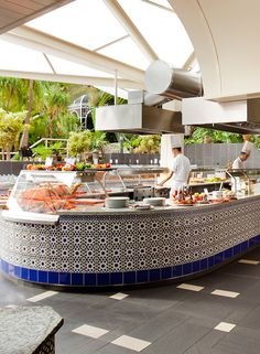 a buffet area with several people preparing food