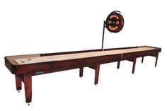 an old style shuffle table with a hockey stick on it's end and a spinning disc in the background