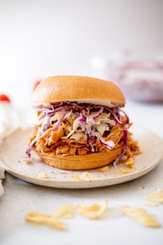 a pulled pork sandwich with cole slaw on a plate