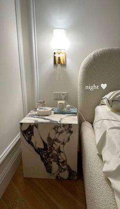 a white chair sitting next to a night stand