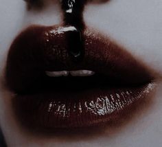 a woman's lips are covered in dark liquid