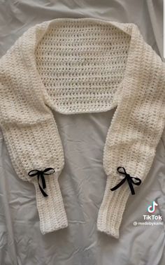 a white knitted sweater with black bow ties