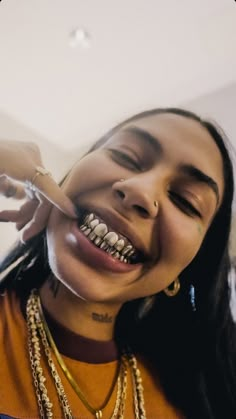 a woman with braces is smiling and holding a toothbrush in her mouth