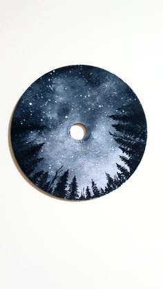 a black and white disc with trees on it