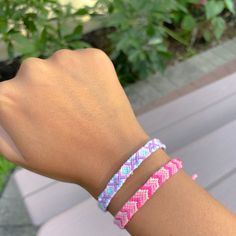 a woman's arm with two bracelets on it, one is pink and the other is blue