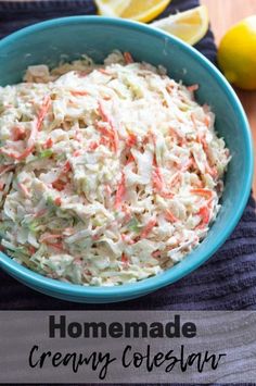 a blue bowl filled with coleslaw next to lemons