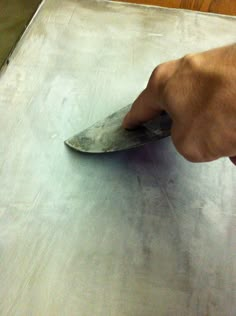 a person is using a knife to cut something on a piece of tin foil that has been placed on the floor