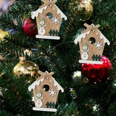 three wooden bird houses hanging from a christmas tree