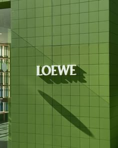 the side of a green building that says loewe on it's wall