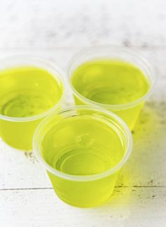 four plastic cups filled with green liquid