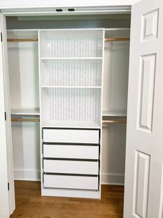 an empty closet with white shelves and drawers