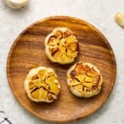 three pieces of fruit sitting on top of a wooden plate