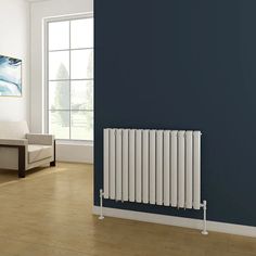 an empty room with a blue wall and white radiator