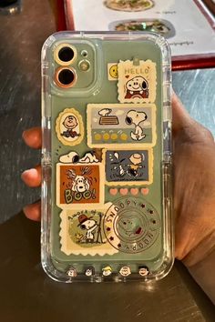 someone is holding up their phone case with stickers on it