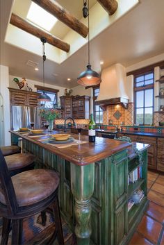 a large kitchen with an island in the middle and two stools at the end