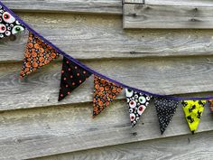 halloween decorations are hanging on the side of a wooden building, decorated with skulls and flowers