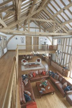 a living room filled with lots of furniture and wooden flooring next to a staircase