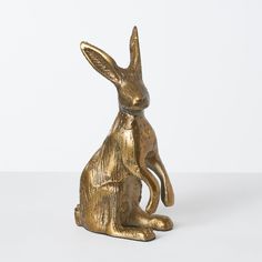 a golden rabbit statue sitting on top of a white table