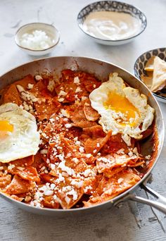 two eggs on top of some meat in a pan