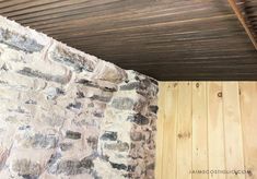 an old stone wall with wood planks on the ceiling