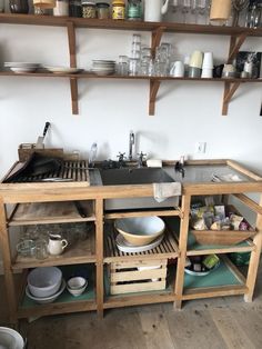 a kitchen with wooden shelves and open shelving