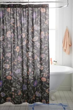 a bathroom with a bathtub, shower curtain and rug