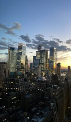 the city skyline is lit up at night, with skyscrapers in the foreground