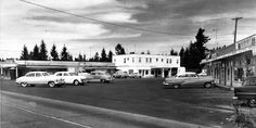 an old black and white photo of cars parked in a parking lot