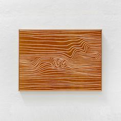 a wooden plaque mounted to the side of a white wall with wavy lines on it