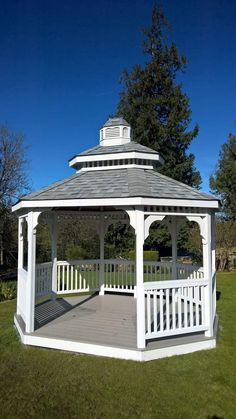 a white gazebo sitting on top of a lush green field