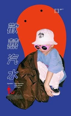 a young child wearing sunglasses and a hat sitting on top of a bag in front of an orange background