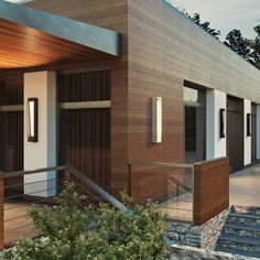 a modern house with wood siding and white trim on the front door, stairs leading up to it