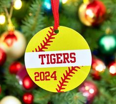 a christmas ornament with the name tigers on it hanging from a christmas tree