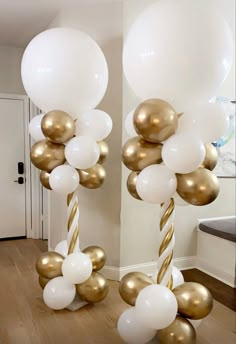 white and gold balloons are hanging from the ceiling