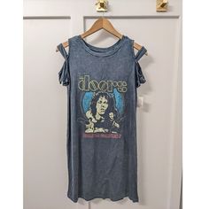 The Doors Band Tee Dress Size Small Brand New With Tags, Nwt This Great Vintage 80s Look Shirt Dress Can Be Worn With Leggings Or Sheer Hose And Belted For An Elevated Night Look Or Simply Worn With Cowboy Boots And A Denim Jacket For A More Casual Look. Great Comfort Piece That Is So Versatile! Acid Wash, Dark Blue Green Color Distressed Doors Band Graphic Front Super Soft Fabric, Stretchy Flowy, Airy Fit Mid-Thigh Length Cold Shoulder Cut Outs Rayon/Spandex Blend Machine Wash Acid Wash Grunge T-shirt With Short Sleeves, Band Tshirt Dress, Bohemian Acid Wash T-shirt For Summer, Band Tee Dress, Distressed Short Sleeve T-shirt For Music Festivals, The Doors Shirt Band, Oversized Distressed Band Merch T-shirt, Distressed Doors, The Doors Band