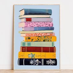 a stack of books on top of each other in front of a white wall with a wooden floor