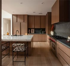 a large kitchen with wooden cabinets and marble counter tops, along with an island in the middle