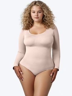 a woman in a nude bodysuit posing for the camera with her hands on her hips