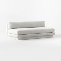 a white couch sitting on top of a white floor