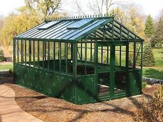 a small green house sitting in the middle of a park