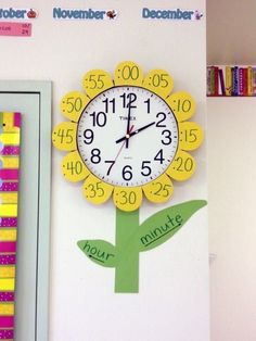 there is a clock on the wall next to a book shelf with books and magnets