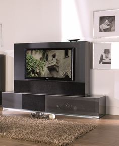 a flat screen tv sitting on top of a black entertainment center in a living room