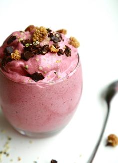 a pink smoothie in a glass with chocolate chips and sprinkles on top